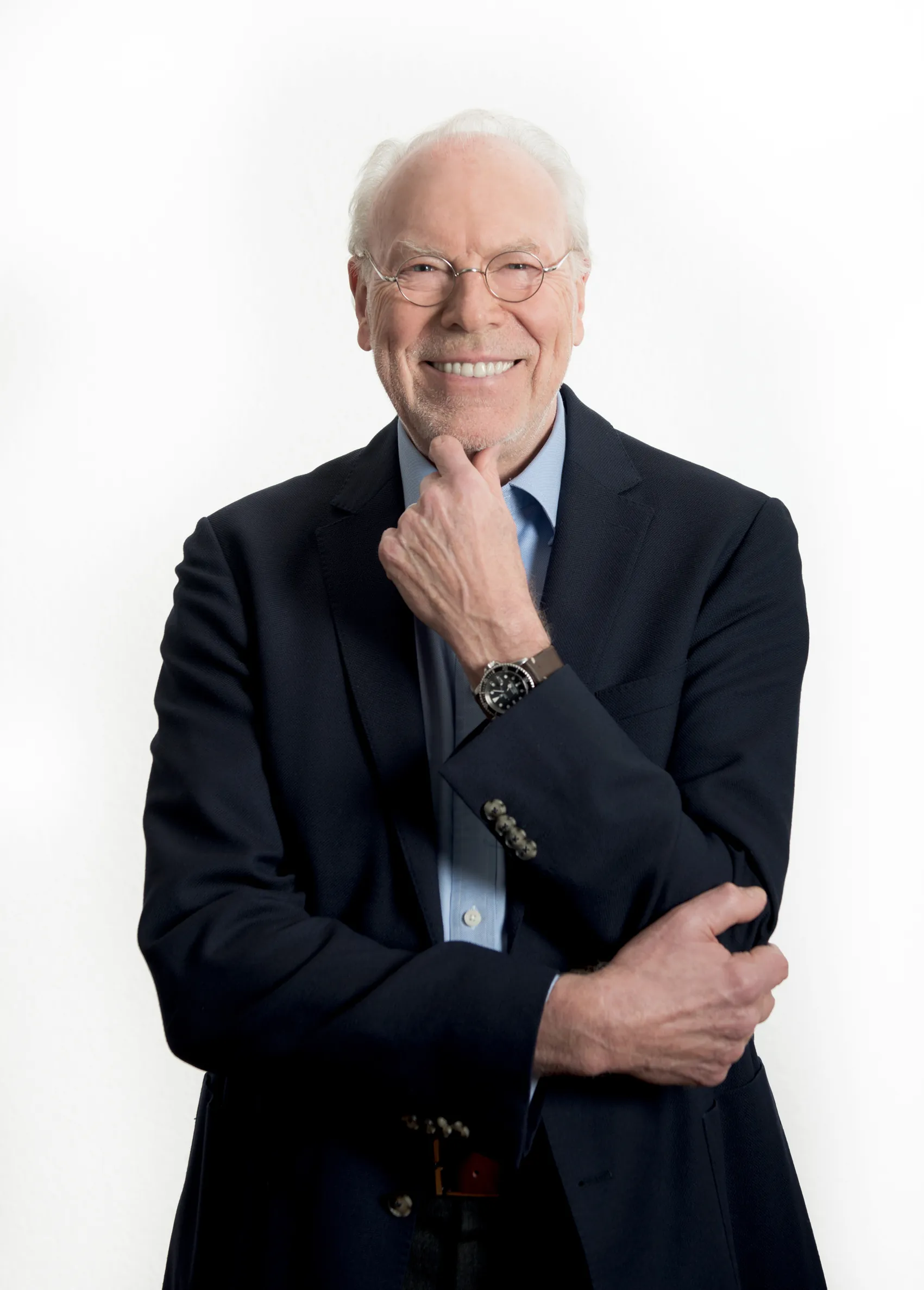 Bernd Behrens in a suit against a white background, his hand thoughtfully on his chin